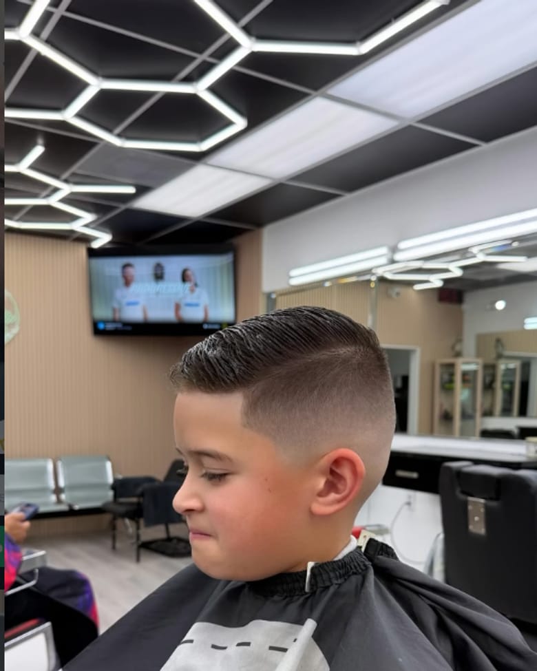 Corte de niño con degradado bajo las luces del salón
